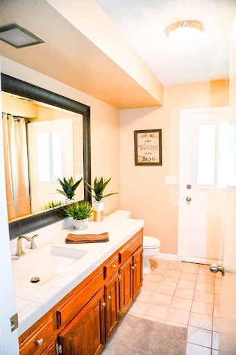 Bathroom with large framed mirror, sink, and wood cabinets