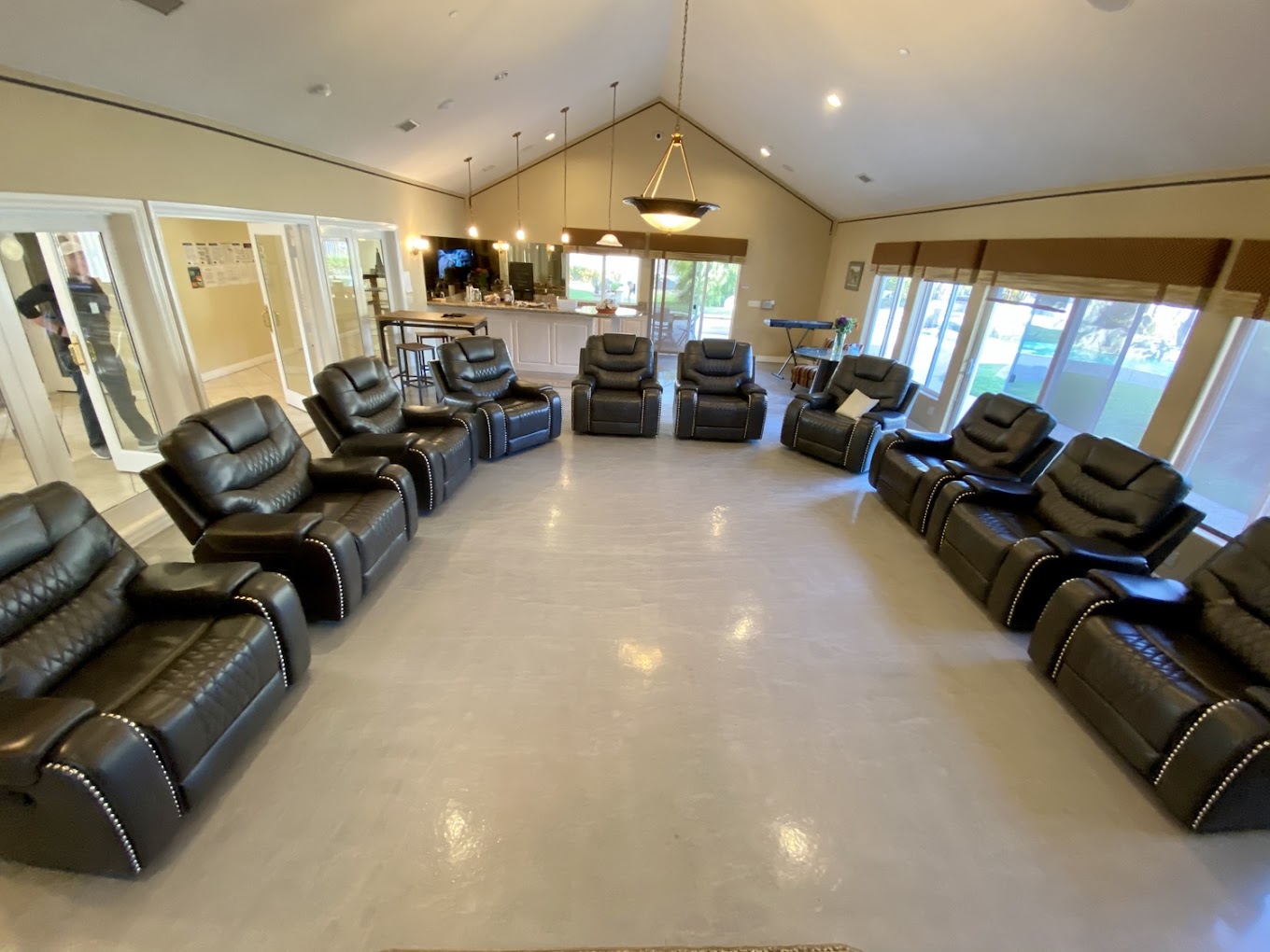 Semi-circle of black recliners in spacious therapy room