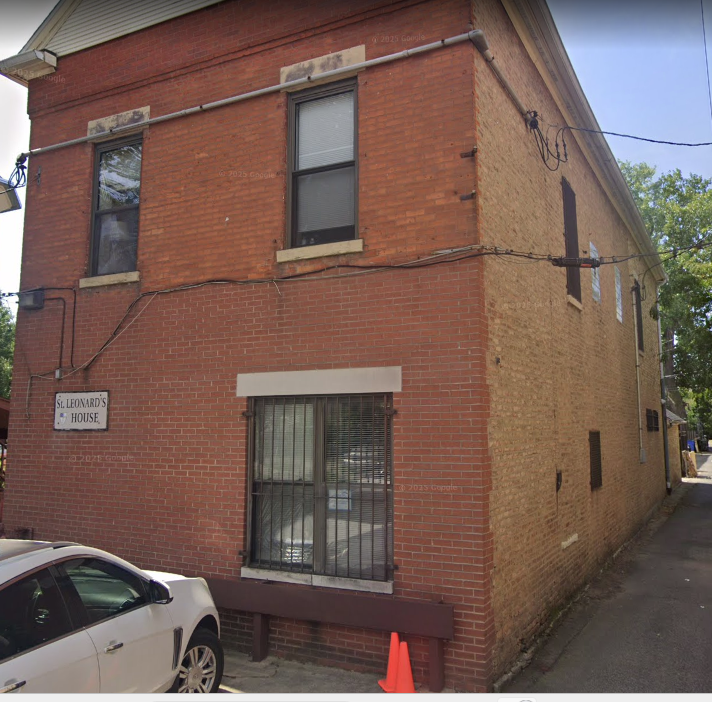 Front view of St. Leonard’s House brick building with windows and a sign.