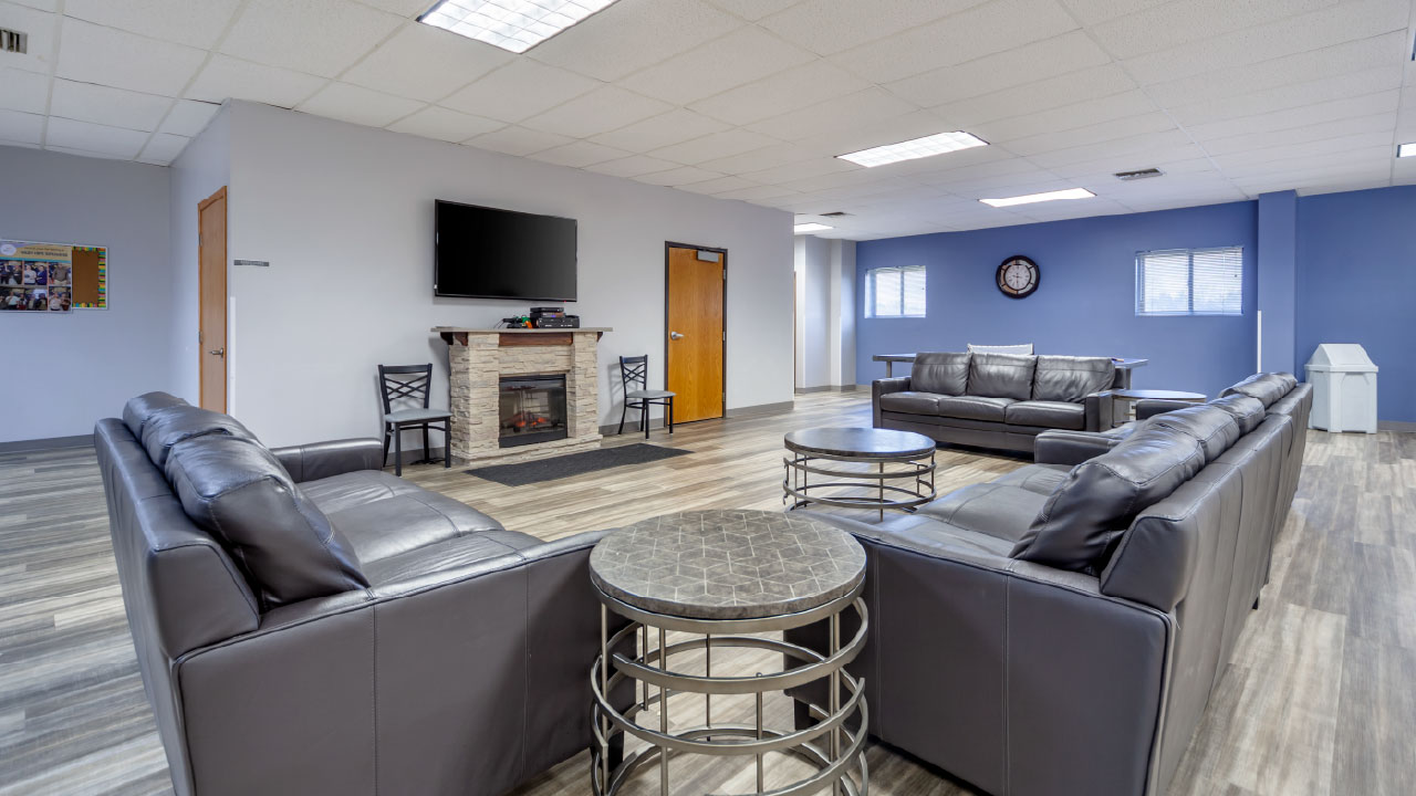 Client lounge with sofas, TV, and fireplace