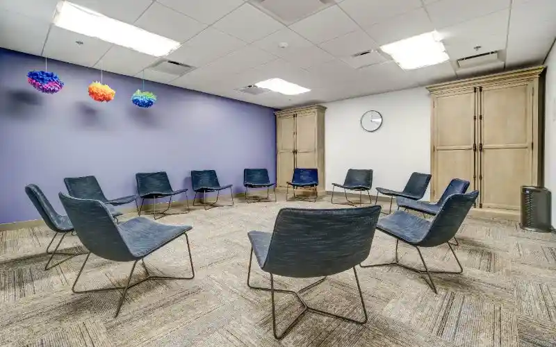 Therapy room with circle of blue chairs and purple accent wall