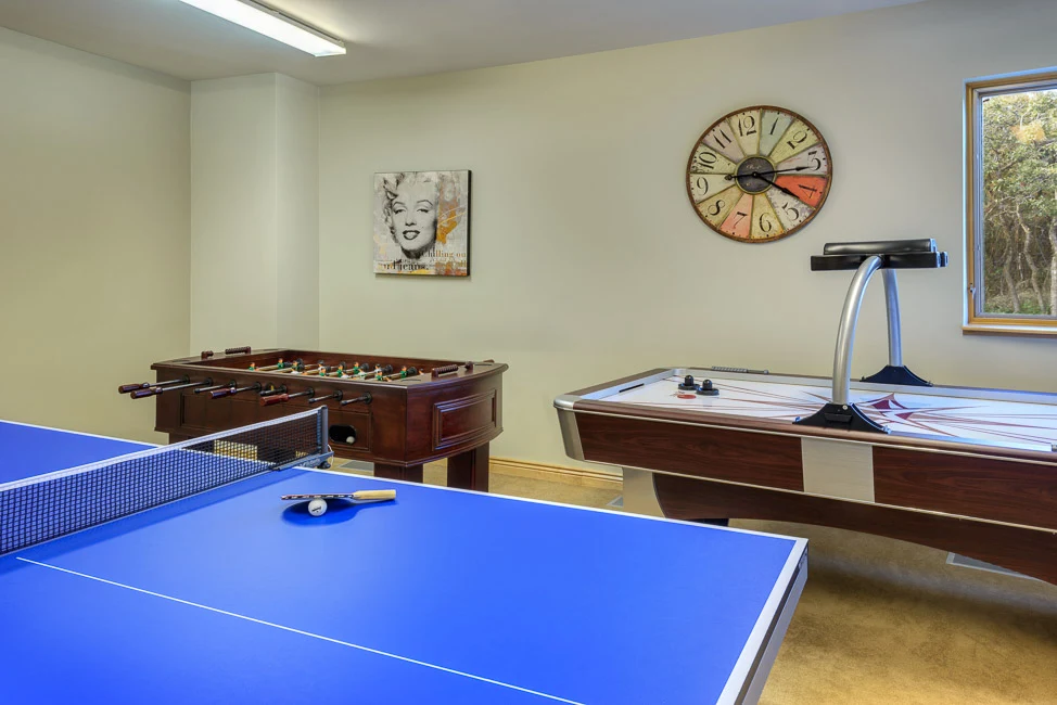 Game room with ping-pong, foosball, and air hockey tables.