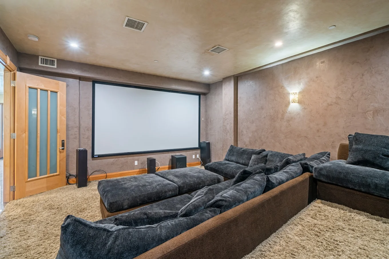 Private theater room with cozy tiered seating and large projection screen
