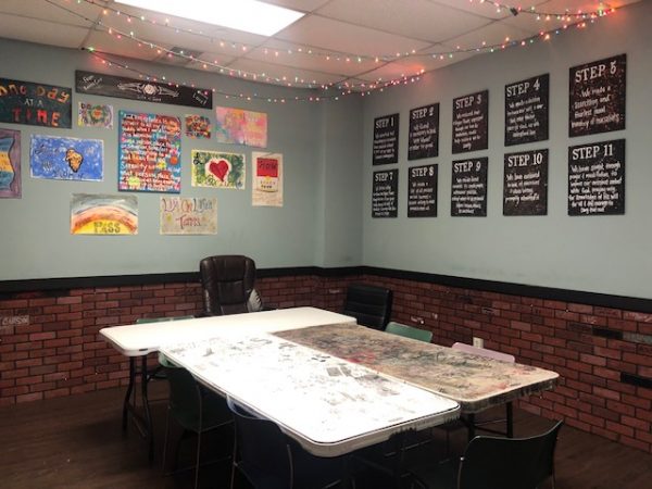 Group therapy room with recovery artwork and meeting table