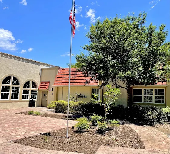 Main entrance with flagpole and red roof