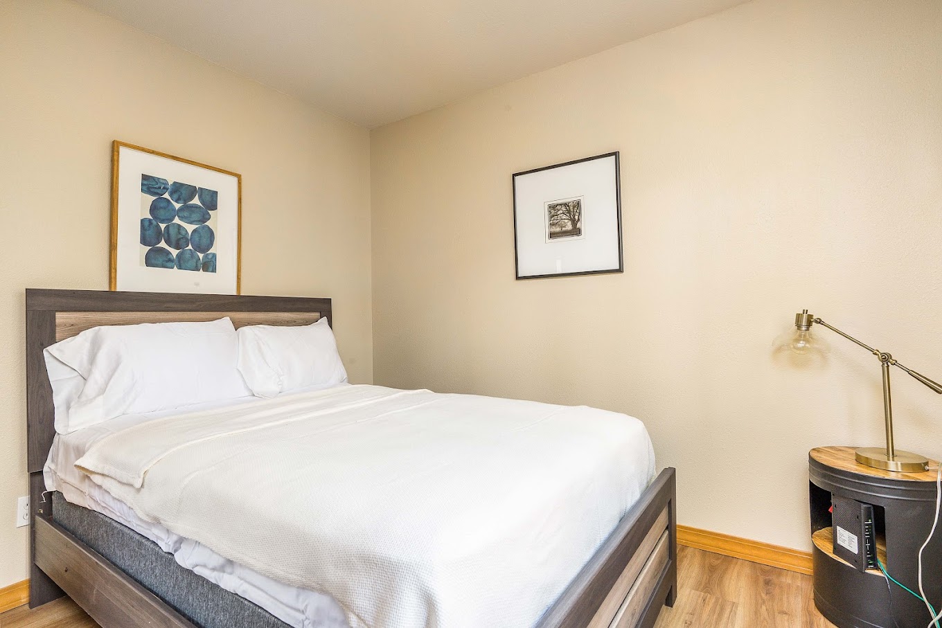 Bedroom with a bed, a lamp and wall art.