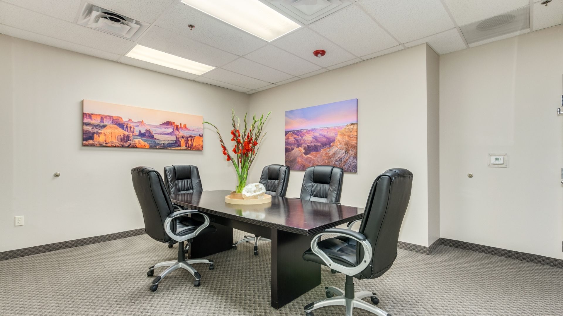 Small meeting room with black chairs and wall art