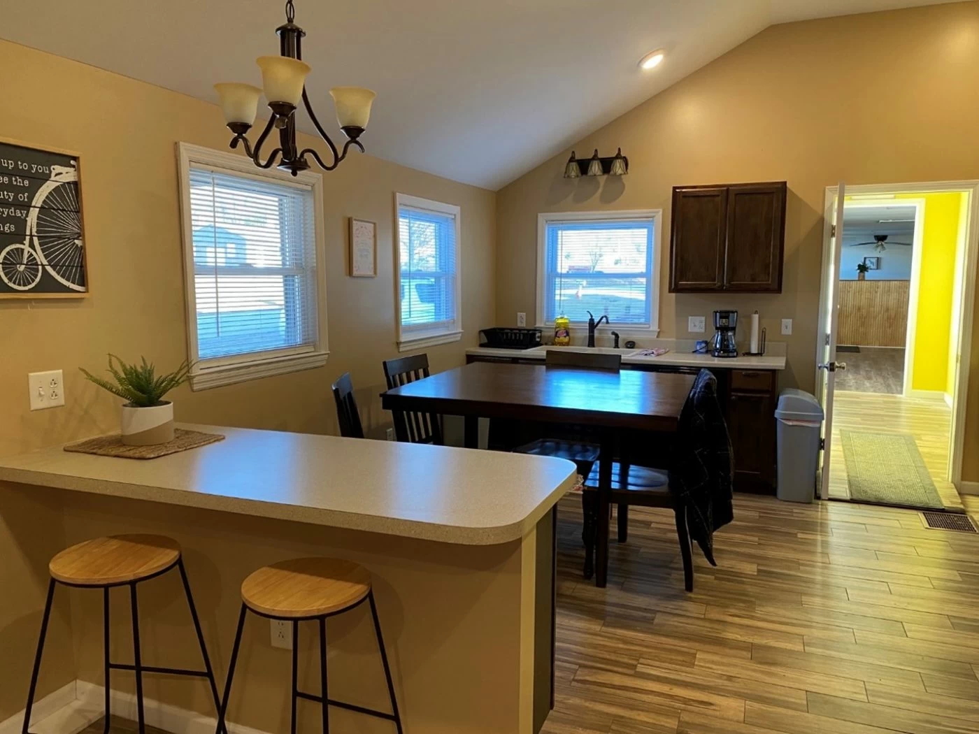 Warm-toned kitchen and dining area with stools and wood floors