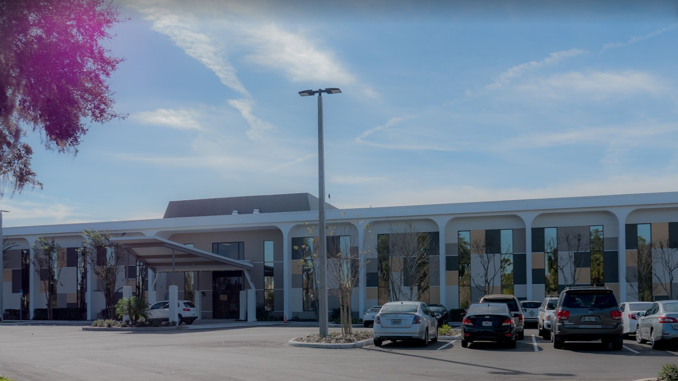 A spacious rehab facility exterior with a parking lot and modern design.