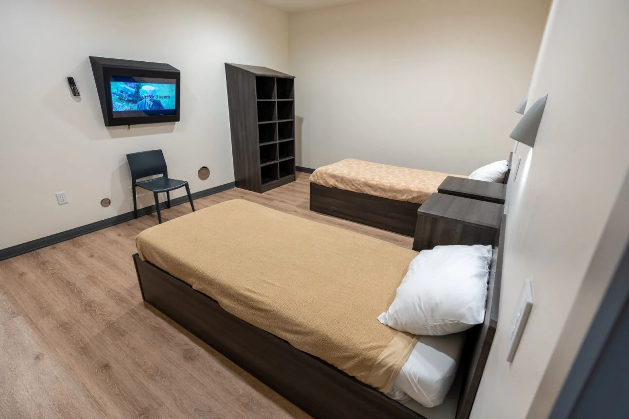Bedroom with two twin beds and wall-mounted TV