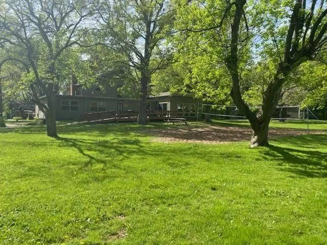 Green outdoor yard with volleyball net and trees