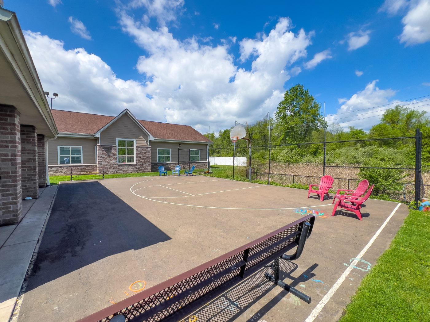 Outdoor basketball court with chairs and open sky