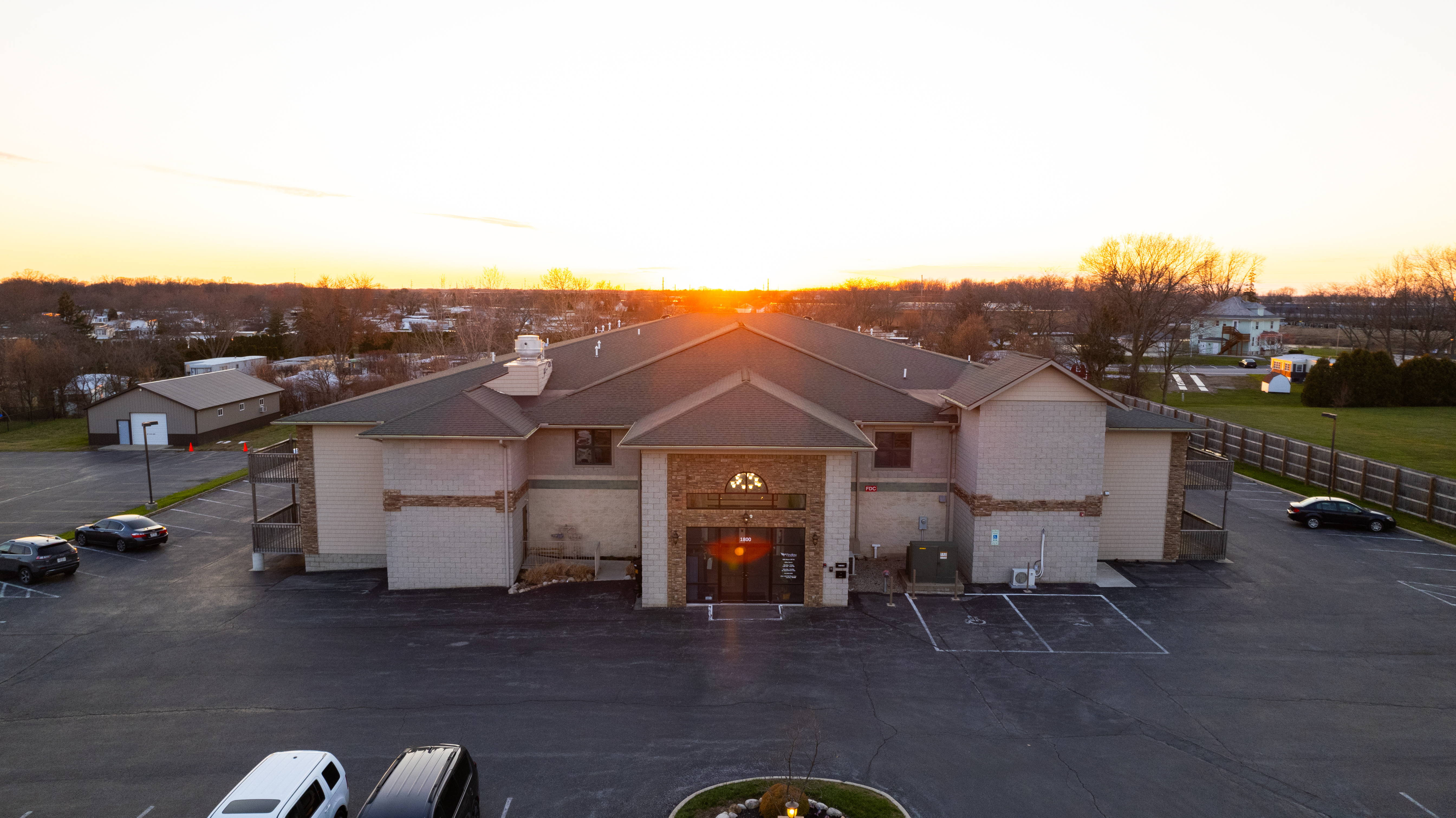 Rehab center exterior at sunset with large parking area