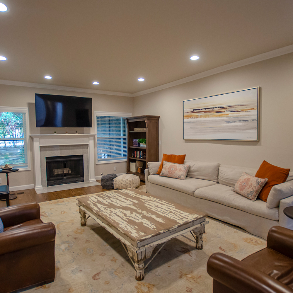 Living room with a fireplace, sofas, and a TV.