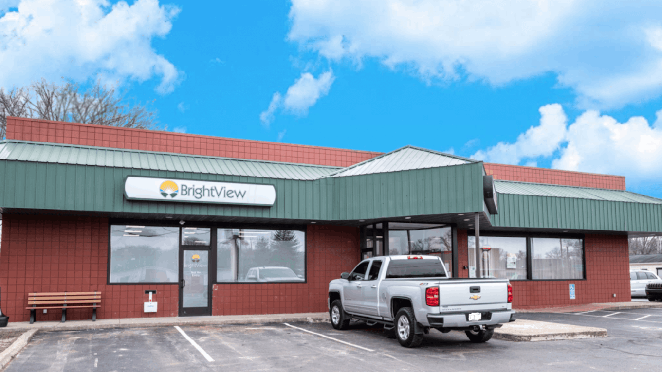 Exterior of BrightView Health Zanesville with red and green facade, BrightView sign, parking spaces, and a silver pickup truck near the entrance