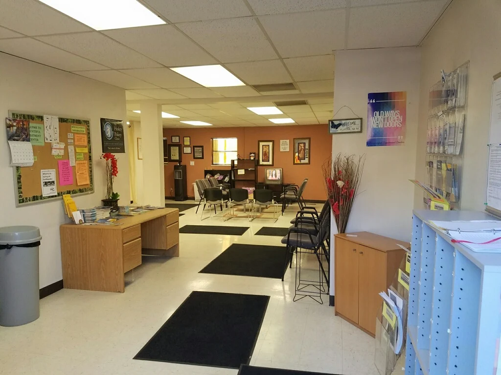 Waiting area with chairs, desk, and bulletin boards