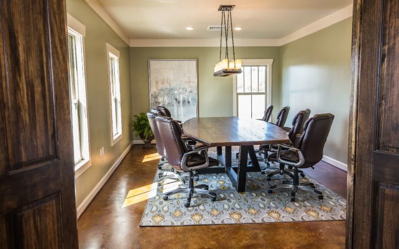 Private meeting room with large wood table and leather chairs