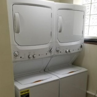 Laundry room with two stacked washer dryers