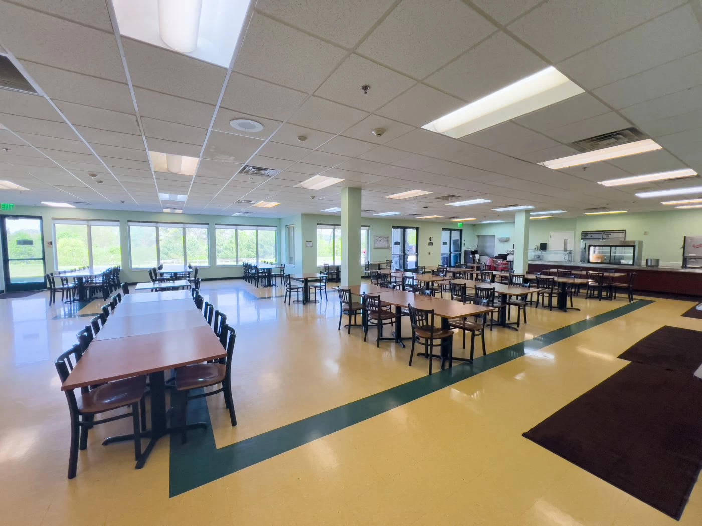 Spacious dining hall with tables and cafeteria service area inside treatment facility