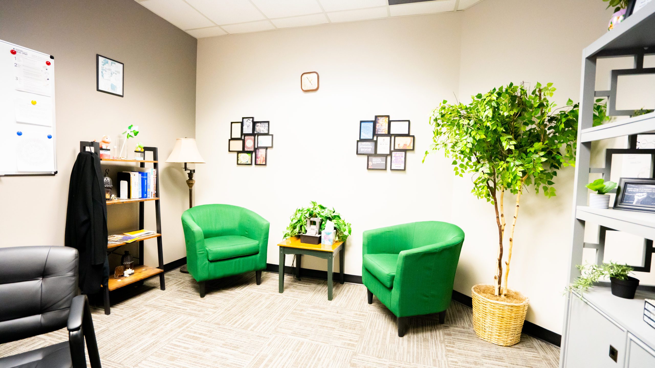 A well-lit office space with green chairs and decorative wall art.