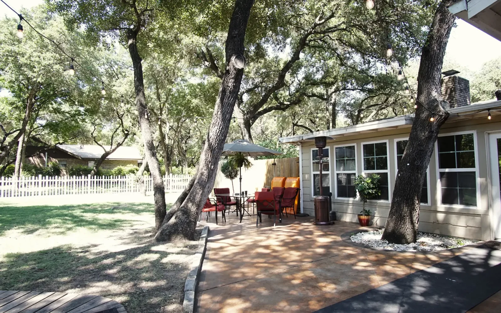 Outdoor seating area with umbrella and string lights