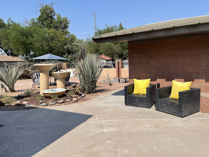 Outdoor area with seating, umbrella, and a mini-fountain.