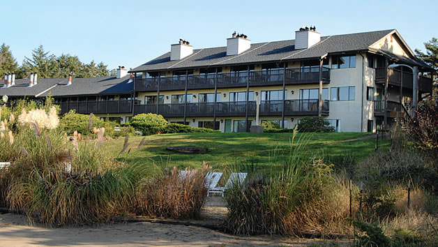A rehab facility with balconies and a well-maintained lawn.