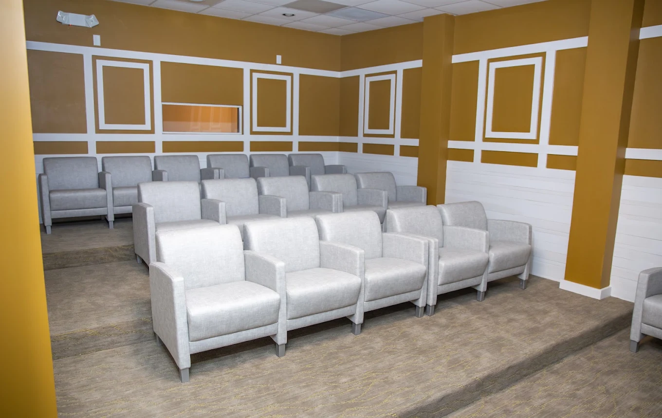 Group room with rows of upholstered chairs and tiered seating