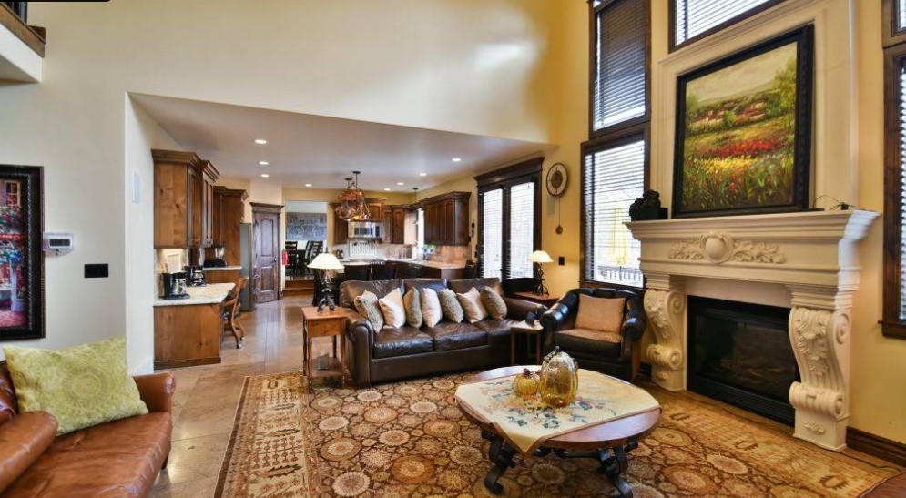 Comfortable living room with fireplace, seating, and open kitchen