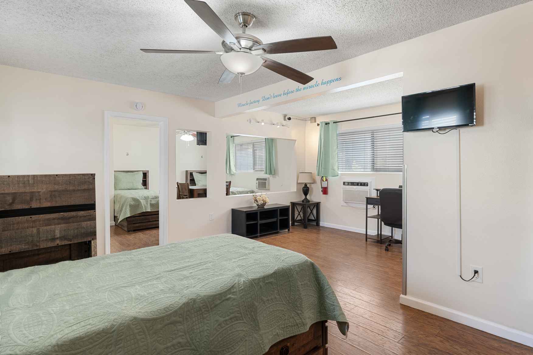 Private bedroom with green bedding and natural light.