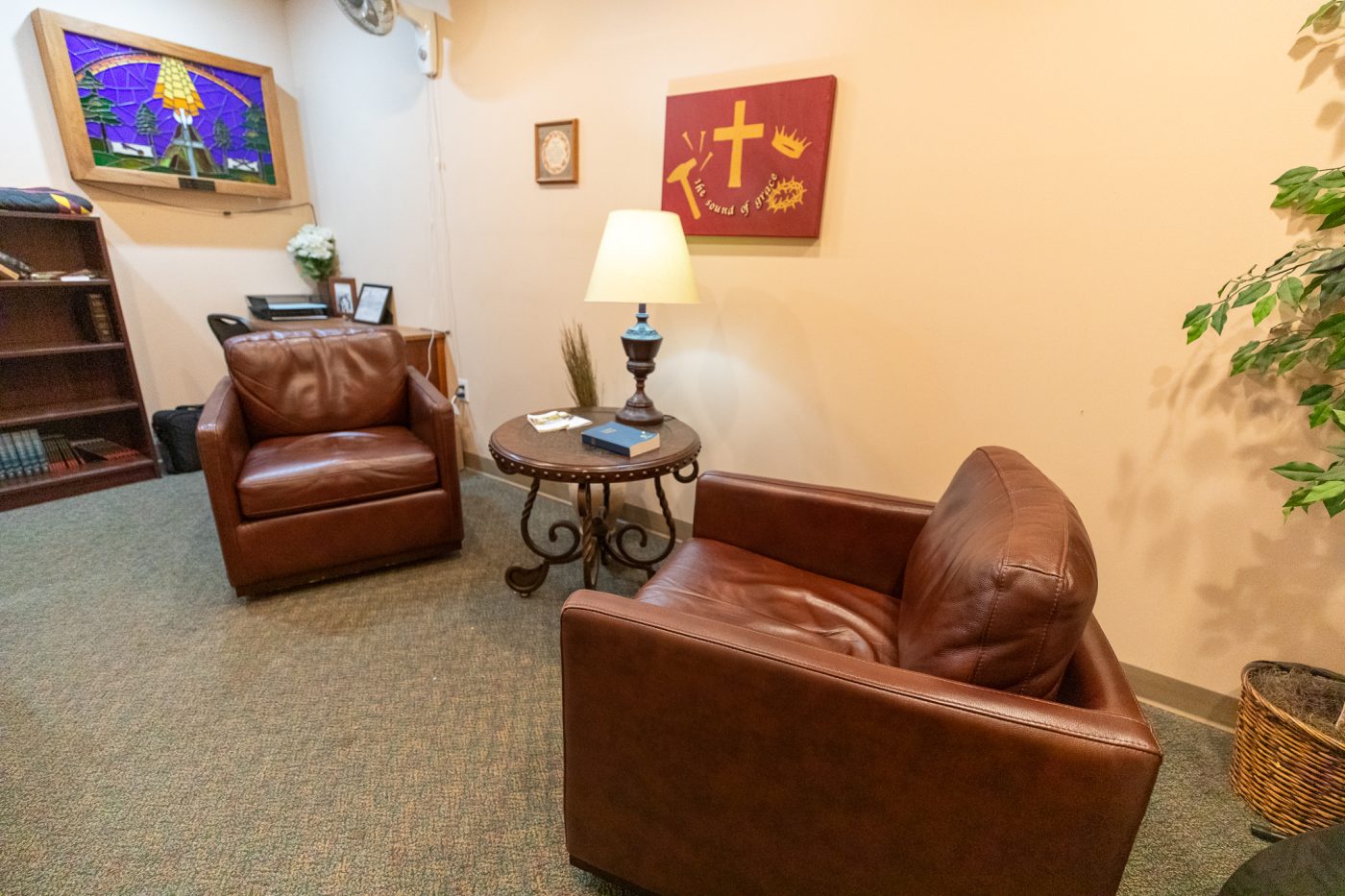 Quiet reflection room with leather chairs, side table, and inspirational artwork at treatment center