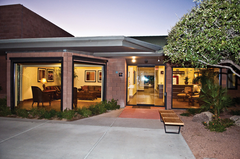 Paved outdoor patio with seating and greenery.