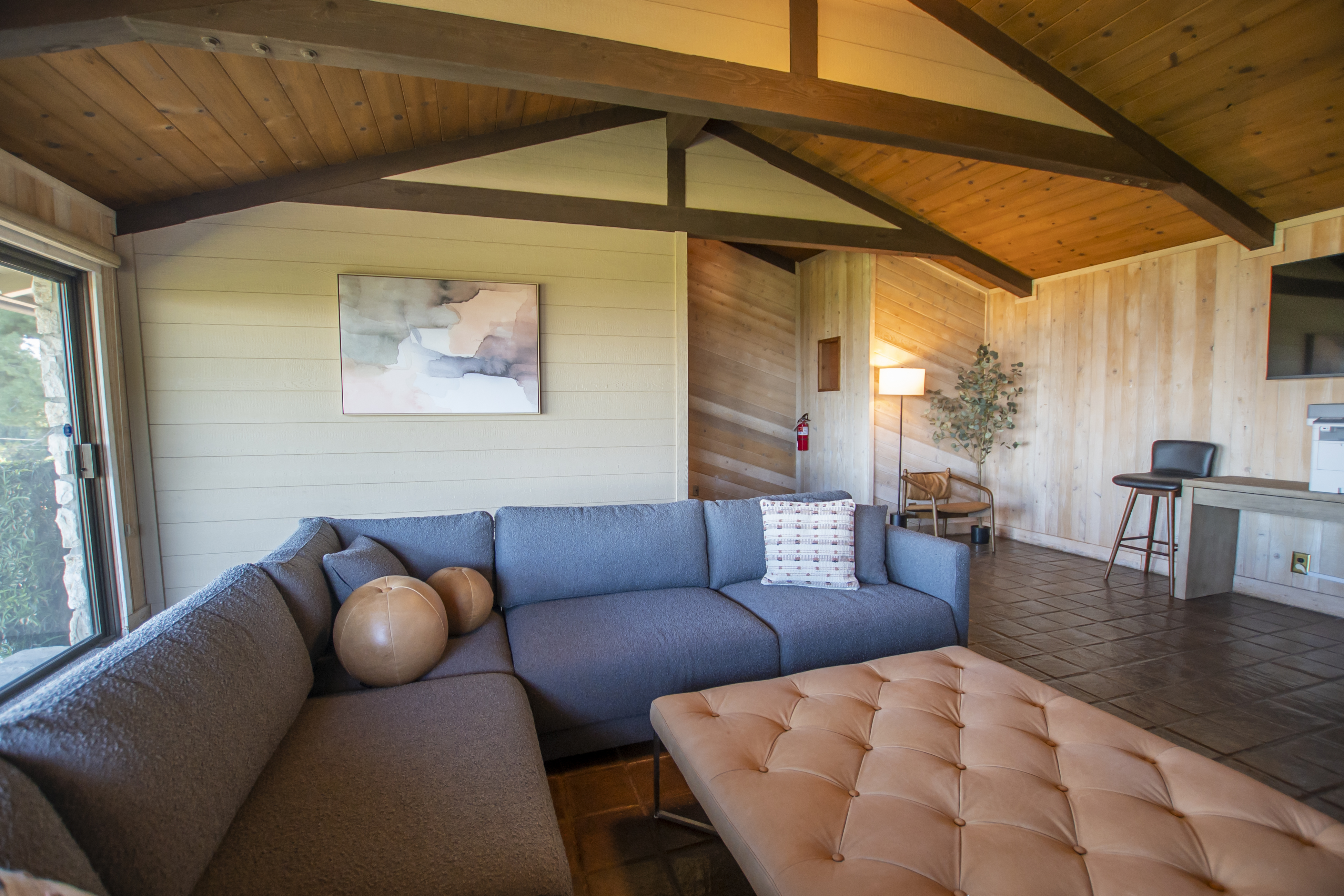 Large sectional couch in a spacious wood-paneled room