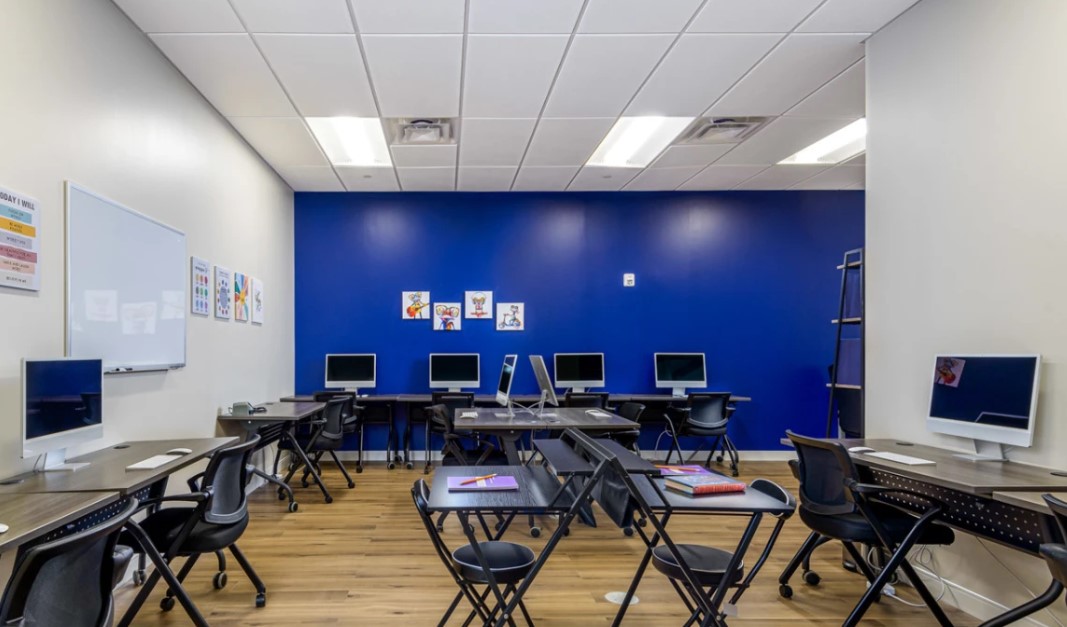 Classroom equipped with computers and desks.