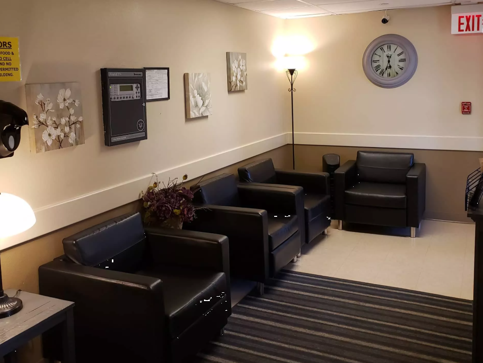 Small lobby with black armchairs and wall clock