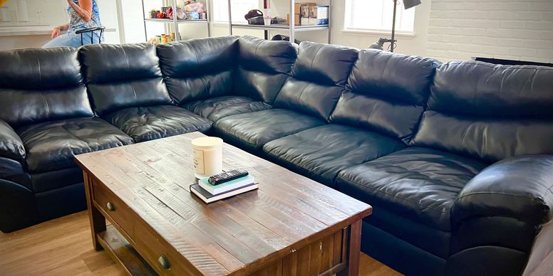 Black leather sectional with coffee table in lounge