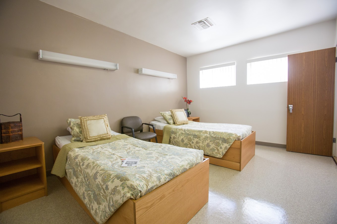 A bright and tidy shared bedroom featuring two comfortable beds with stylish bedding, providing a peaceful and restful environment.