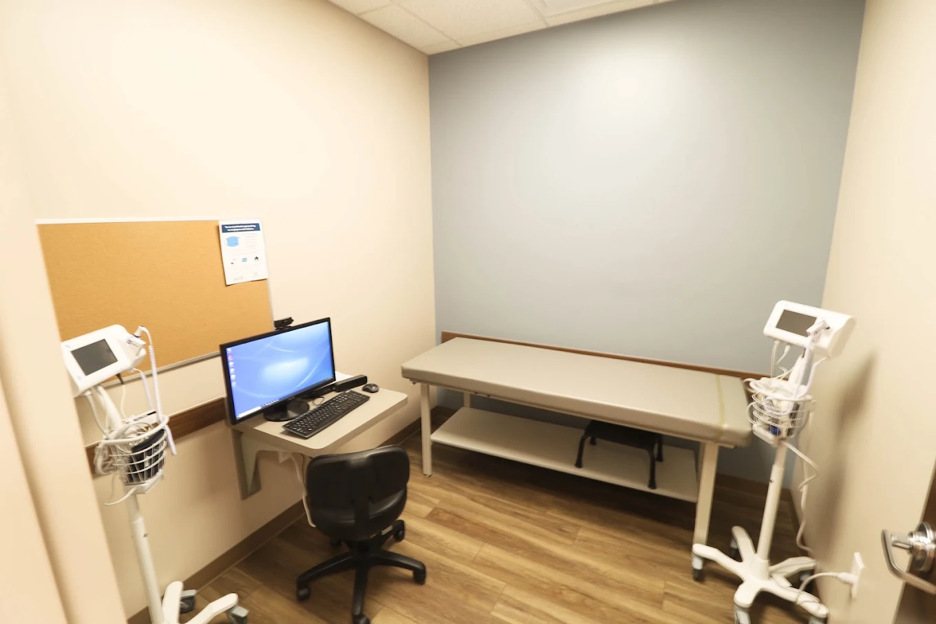 Medical exam room with bed, chair, and counter