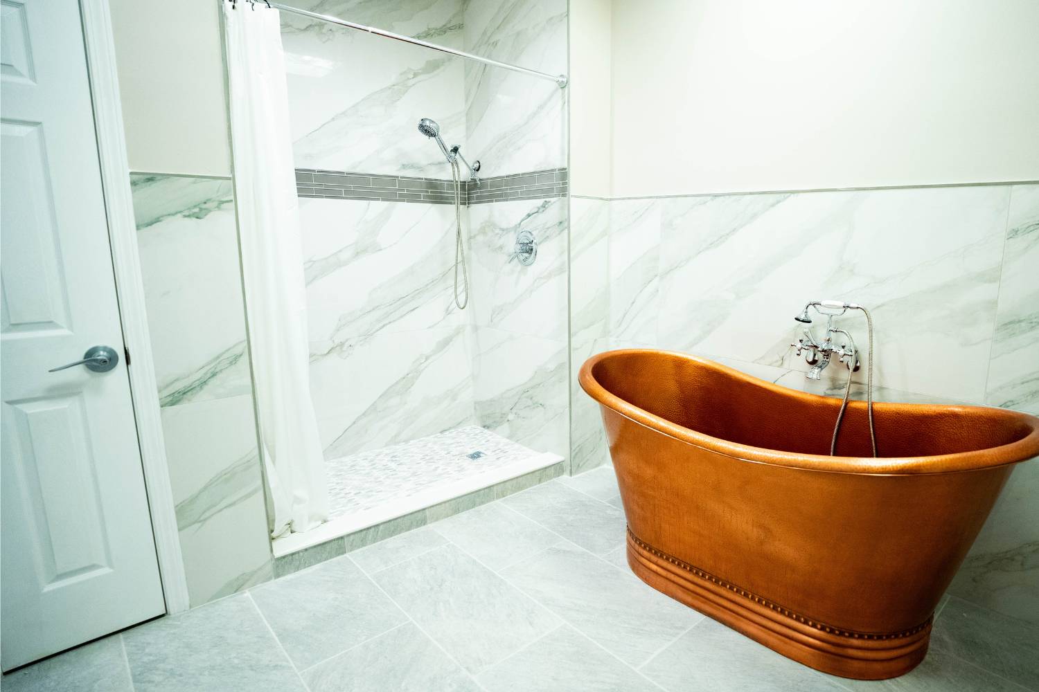 Luxurious bathroom with a copper bathtub and marble walls.