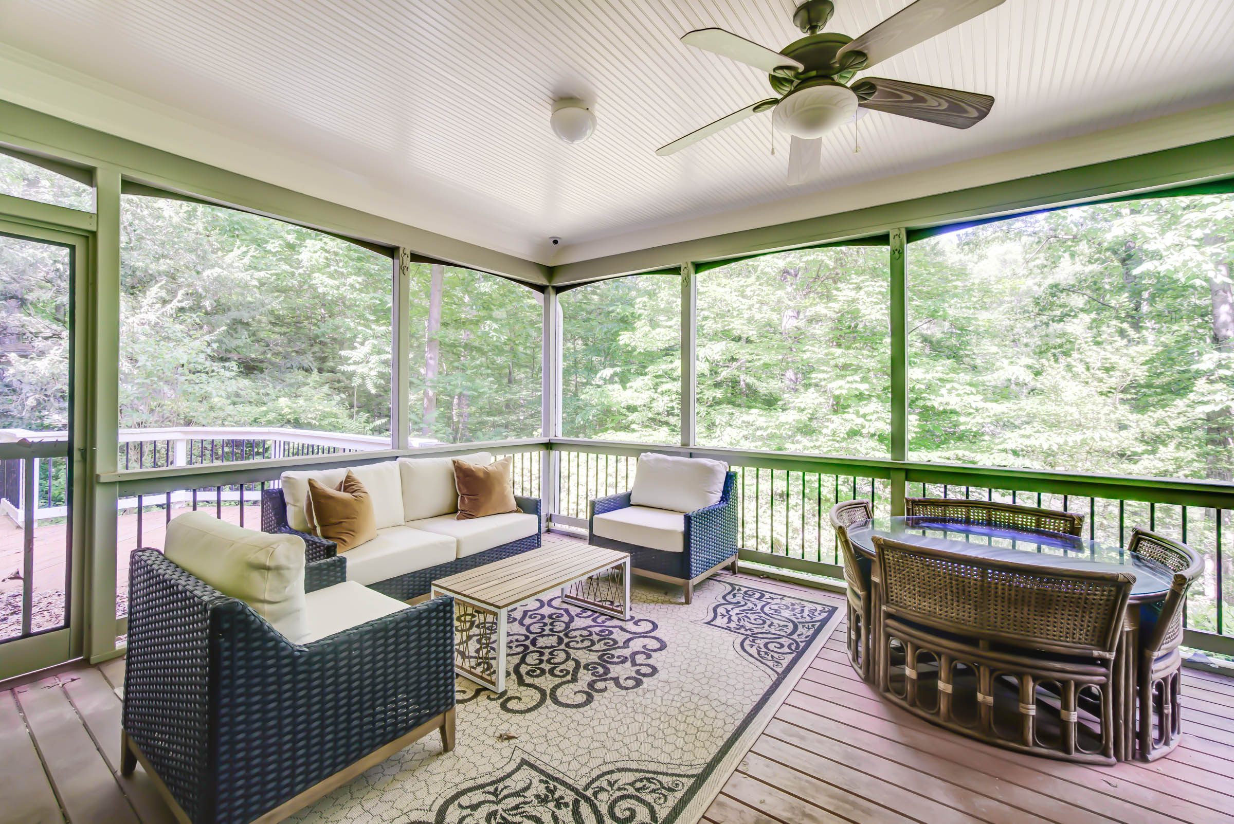 Covered porch with outdoor seating and forest views.