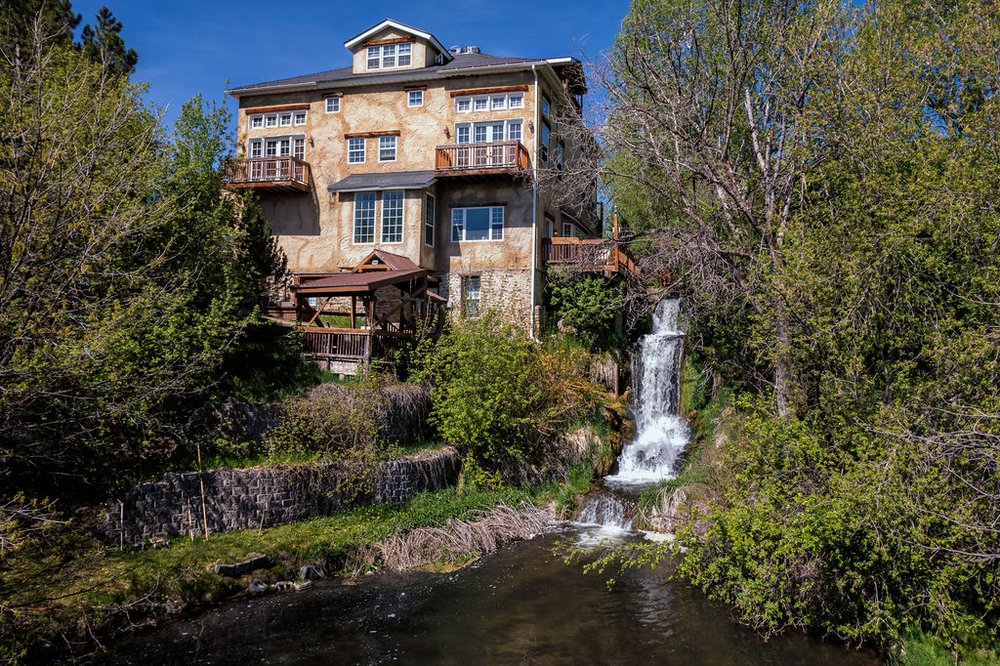 Facility exterior with a waterfall and outdoor lounge.