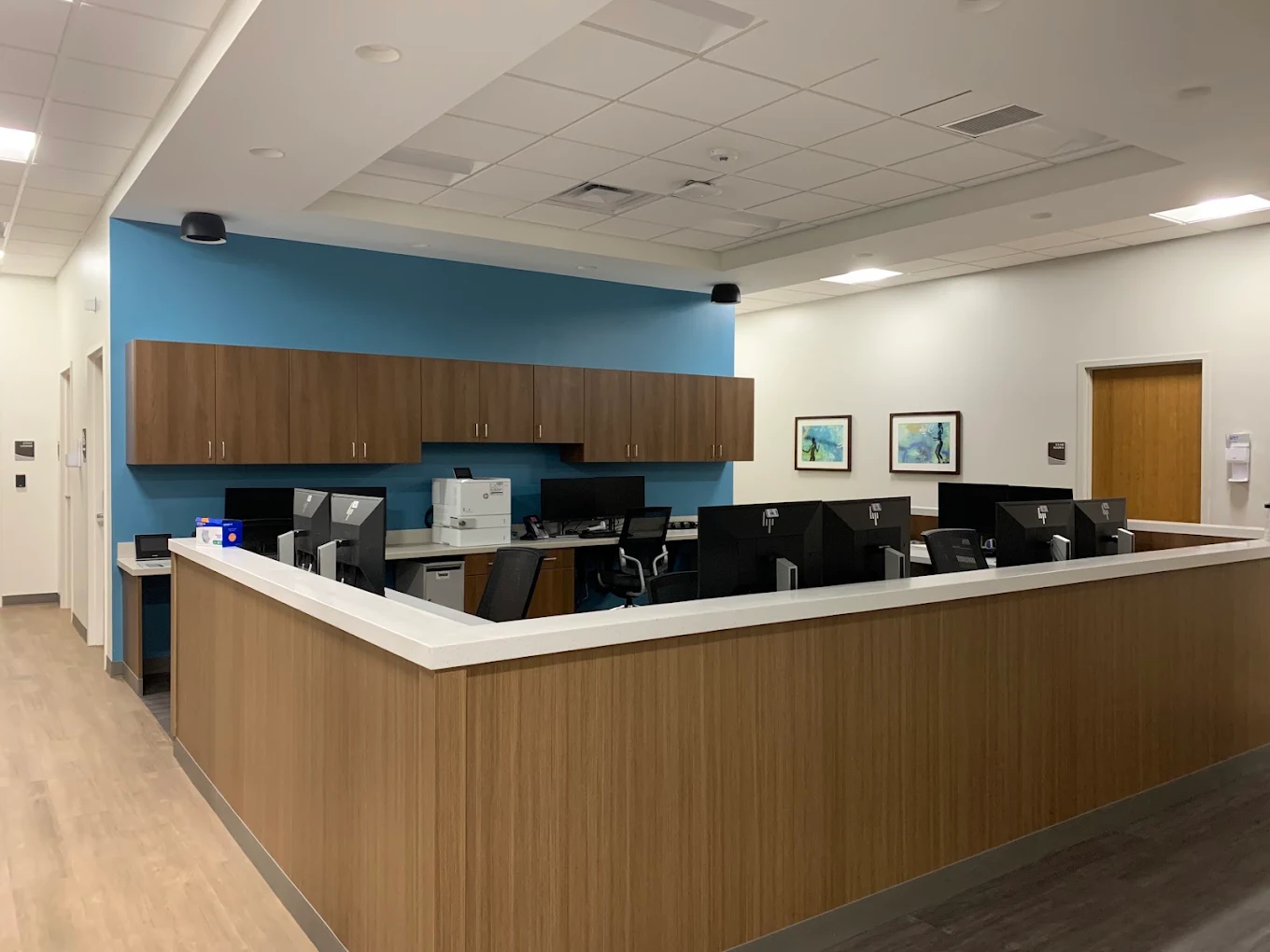Staff workstation with computers, cabinets, and reception counter