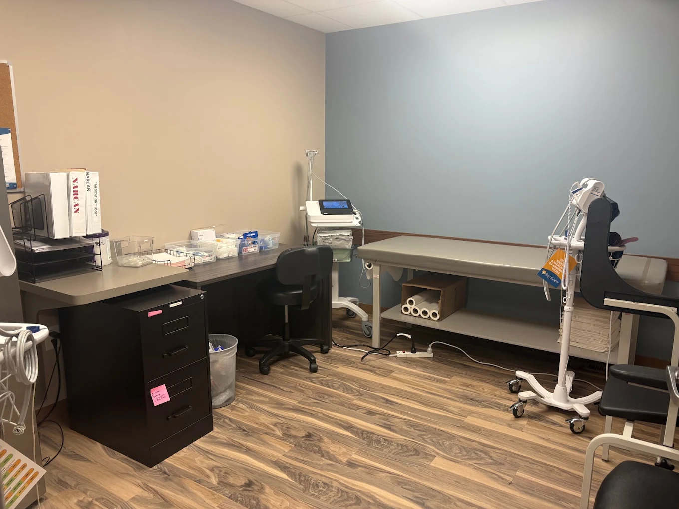 BrightView Akron exam room with examination table, medical equipment, supplies, seating, and blue accent wall