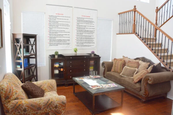 Cozy living room with sofas, coffee table, and staircase