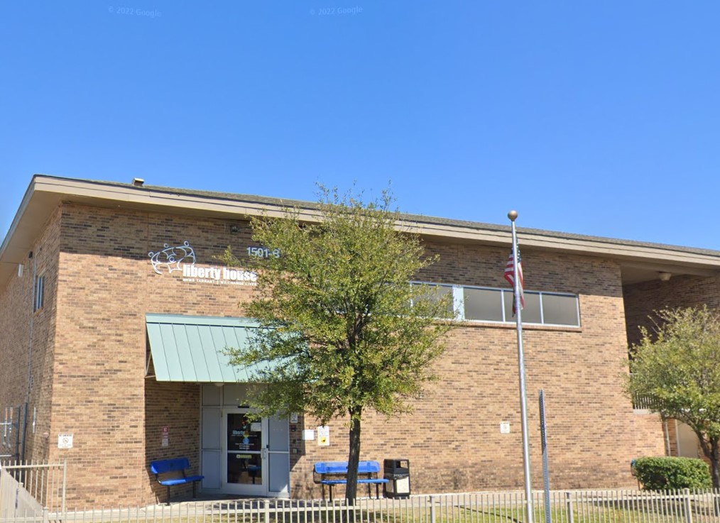 Entrance of a brick detox facility with a large sign and well-maintained landscaping.