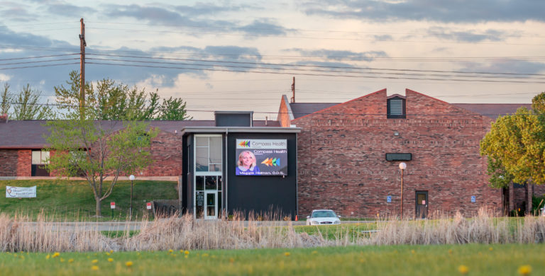 Exterior of Compass Health outpatient building at sunset.