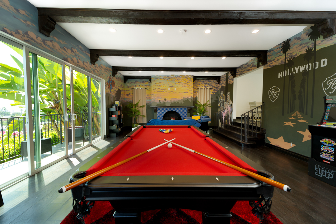 Game room with red pool table and Hollywood-themed wall art