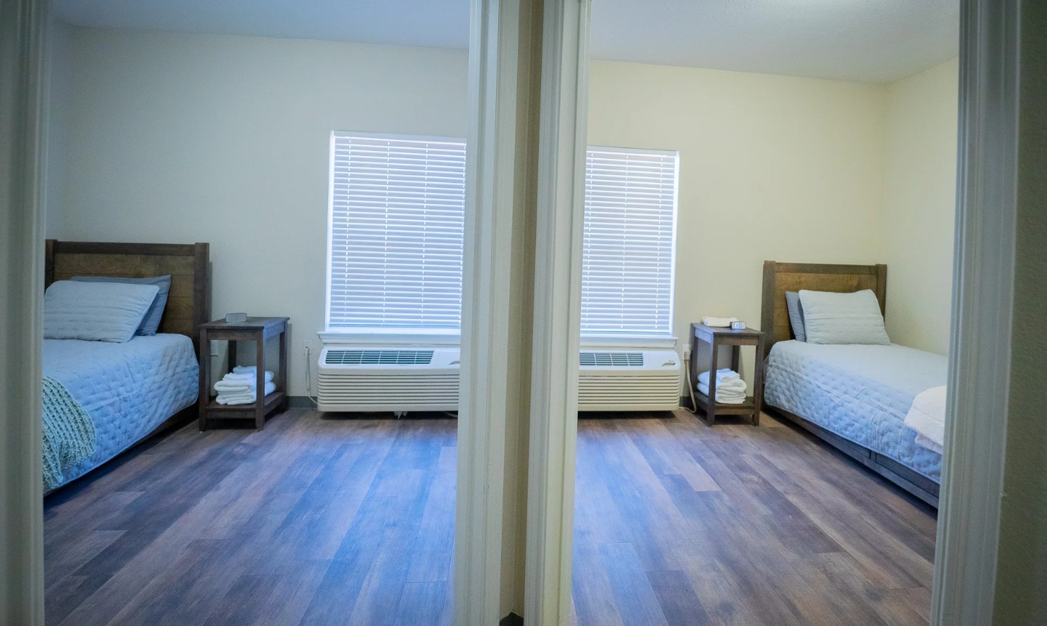 Private client bedrooms with comfortable beds, bedside tables, and natural light at Promises Dallas–Fort Worth