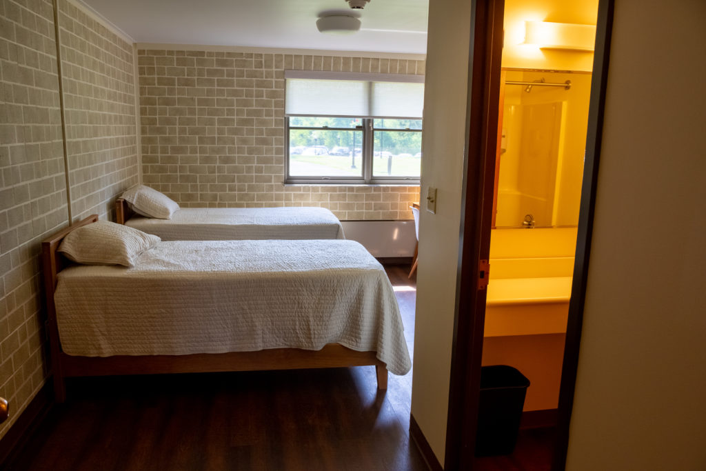 Two single beds with white bedding and private bath access