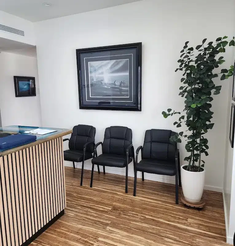 Black chairs and ocean artwork in the waiting area